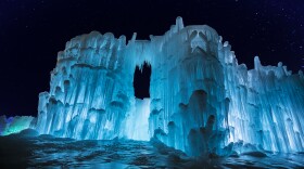 The New Hampshire Ice Castles illuminated with blue light at night.