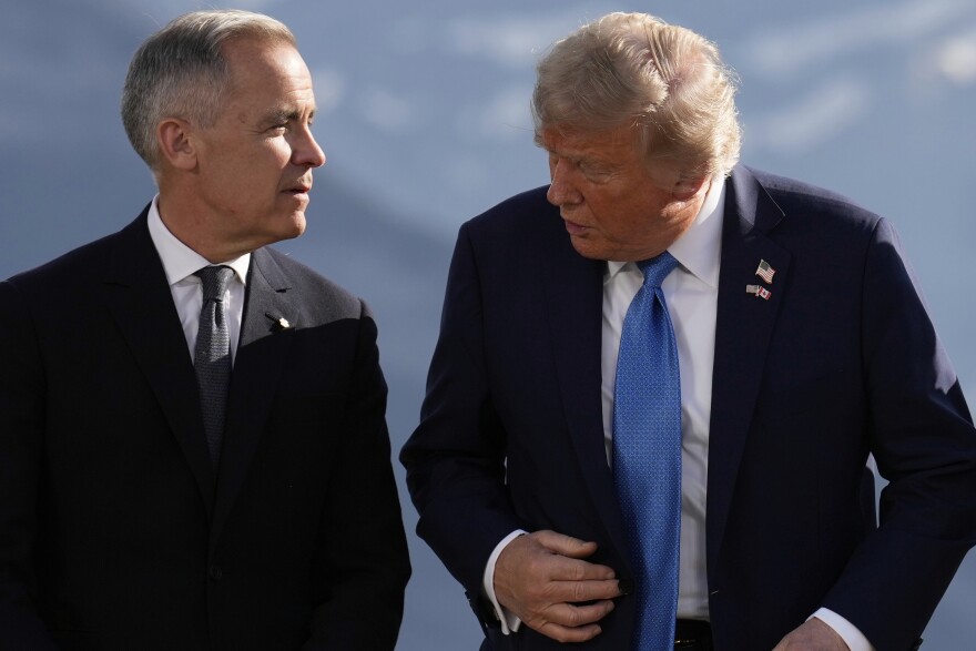 Canada's Prime Minister Mark Carney and President Donald Trump talk before a group photo at the G7 Summit, Monday, June 16, 2025, in Kananaskis, Canada.