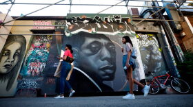 People walk by a mural of late American novelist and activist James Baldwin (C) in Toronto, Canada.
