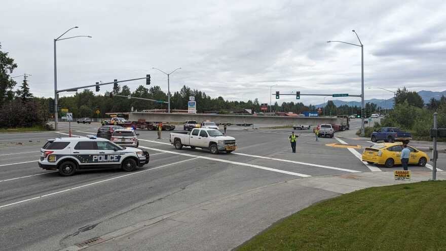 Police vehicles and others around an intersection where a man drove his truck into a 150-foot concrete girder