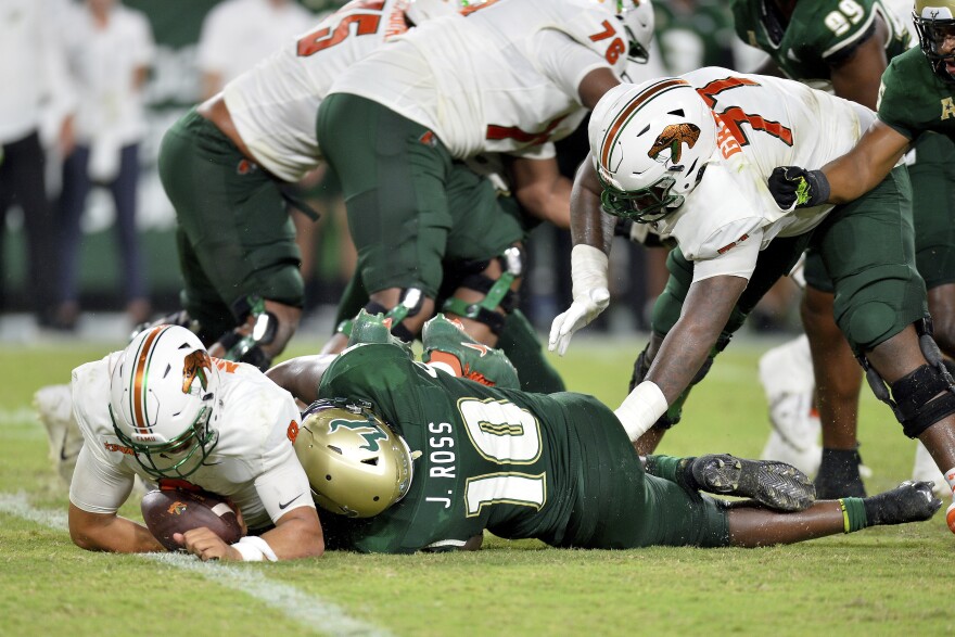 University of South Florida, defensive back, Jonathan Ross (10), sacks FAMU quarterback, Jeremy Moussa (8) for a loss of yards during an NCAA football game on Saturday, Sept. 9, 2023, in Tampa, Fla. (AP Photo/Kelly Sheehan)