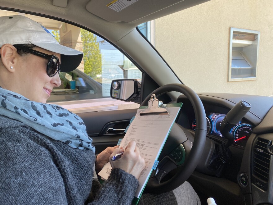 Amy Gore, a small business owner in Seiling, Okla., signs her paycheck protection loan papers in the drive thru of the Seiling State Bank last Thursday.