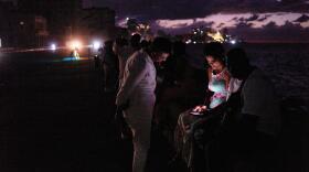People spend the night in the dark on the Malecon during a blackout in Havana, Cuba, Saturday, March 21, 2026. (AP Photo/Ramon Espinosa)