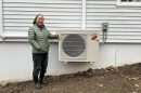 Janet Altobello stands with her new heat pump on a chilly November day.