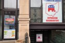 A sign posted on a building with glass windows announces the location of the Washington County republican headquarters. Another says, "No More Injection Wells in Washington County."