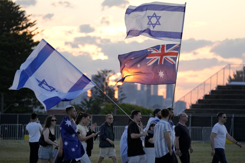 People carry flags as members of the Jewish community gather at a park in Sydney, Australia, on Monday, Oct. 7, 2024, as mourners marked the anniversary of the Oct. 7, 2023, attack in Israel. (AP Photo/Rick Rycroft)