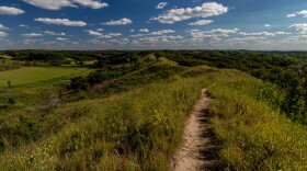 The Loess Hills are shown with green grass and a blue sky.