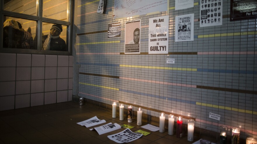 A demonstrator peers at a memorial to Akai Gurley at a public housing complex in Brooklyn, N.Y. Gurley was shot and killed by an NYPD officer in November 2014.