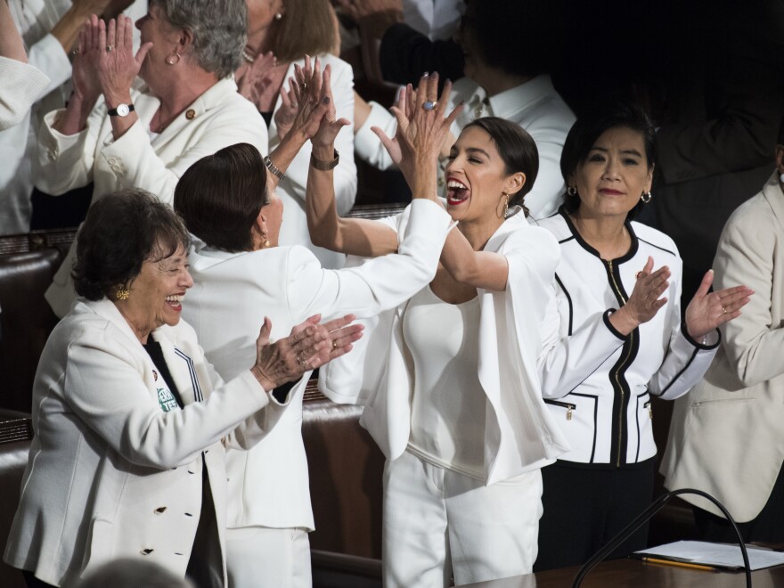 Reps. Alexandria Ocasio-Cortez, D-N.Y. (third from left), high-fives Nydia Velazquez, D-N.Y., as Democratic members celebrate in the House chamber after President Trump recognized their achievement of electing a record number of women to Congress.