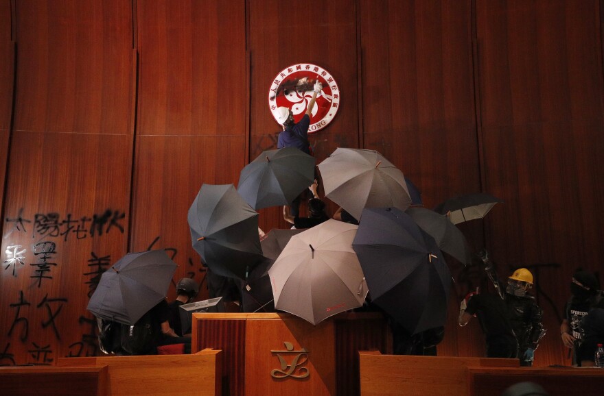 Protesters deface the Hong Kong logo at the Legislative Council to protest against the extradition bill in Hong Kong on July 1, 2019.
