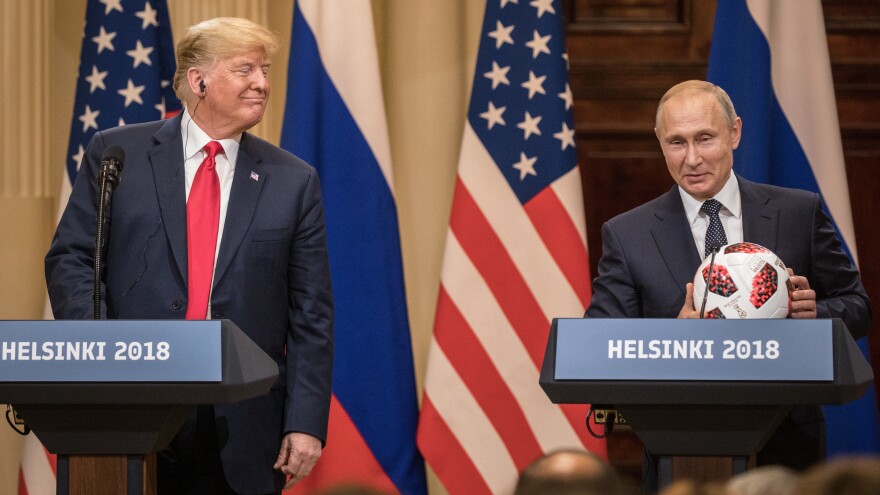 Russian President Vladimir Putin offers a World Cup football to President Trump during a joint news conference after their summit on July 16, 2018, in Helsinki.