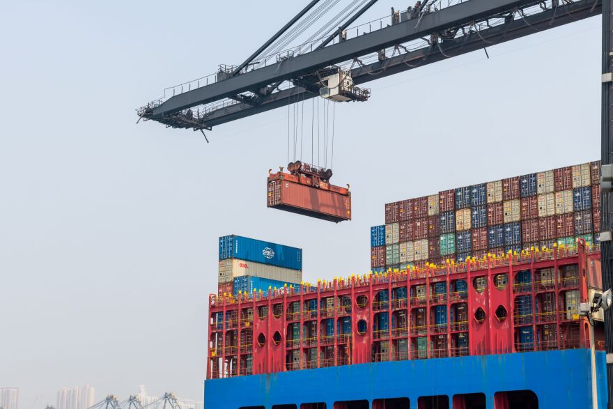 A ship to shore crane in the Port of Hong Kong lifting a shipping container onto a large cargo vessel. Indiana’s Senators are discussing recent tariffs.