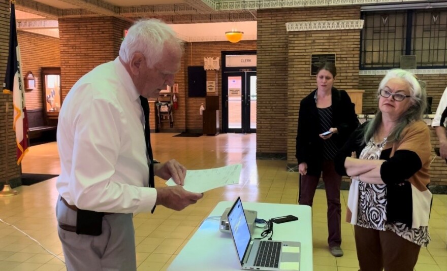 Woodbury County Auditor and Election Commissioner Pat Gill reads absentee ballot results at the county courthouse after the polls closed during the city/school election. Voter turnout was higher than projected at almost 25%.