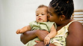 A mother hugs her infant
