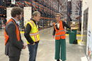 Erin Pulling, right, CEO of Food Bank of the Rockies, talks to U.S. Sen. Michael Bennet, middle, and Ron Meehan, government relations manager for Feeding Colorado in a large warehouse.