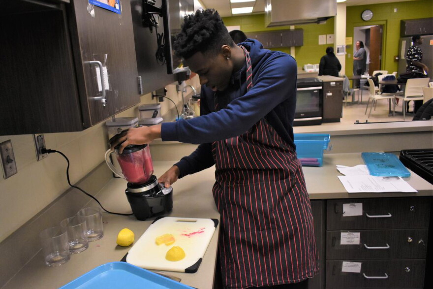 A student in a nutrition class makes a smoothie for a class assignment.