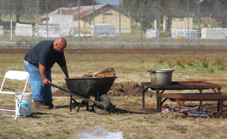 Man hauling firewood in wheelbarrow. 