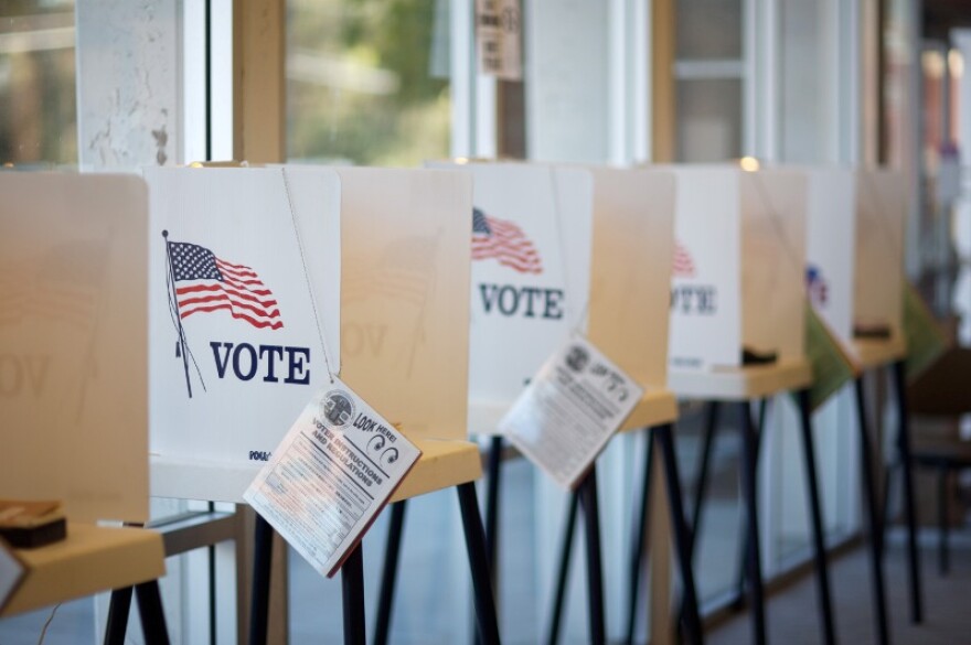 A row of voting booths with instruction booklets for voters