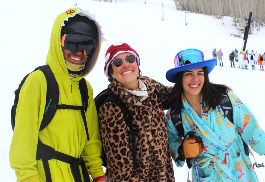 Nia Brinkley (far left), Evin Harris, and Kali Harris gear up for the after-hours naked ski lap at Boot Tan Fest on March 29, 2024. The trio came to the festival to help represent Coalition Snow, a women-owned ski and snowboard company that offers free demos and discounted gear.