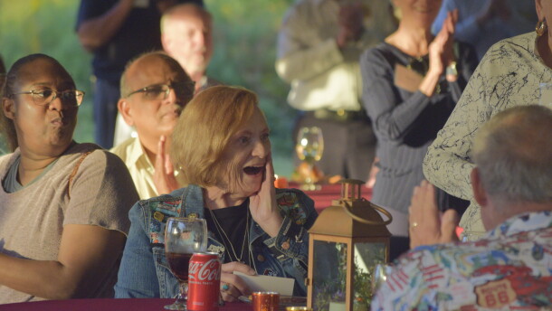 A woman looks at the crowd behind her in surprise. 