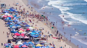 Beach goers watch during the the 46th Annual California Surf Lifesaving Championships on Will Rogers State Beach Friday, July 24, 2026, in the Pacific Palisades section of Los Angeles.