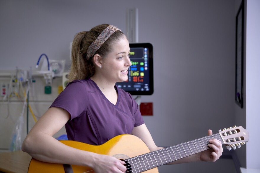 FSU alumna Ciele Gutierrez offers medical music therapy to a baby in the neonatal intensive care unit.