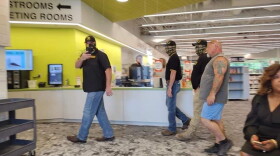 Proud Boys and other protestors walking through the Pine Valley Library. New Hanover County Chief DEI Officer Linda Thompson is seated on the right.