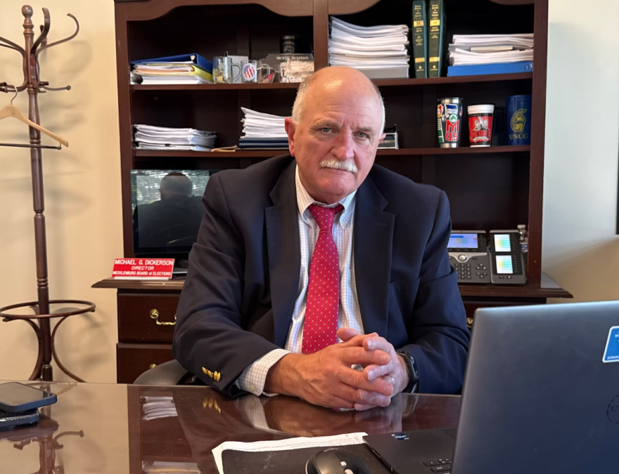 Stern man with mustache at desk