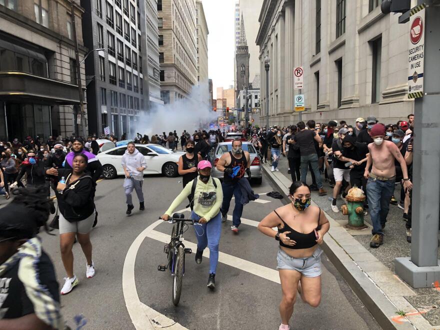 Protesters run from smoke during a protest May 30, 2020.