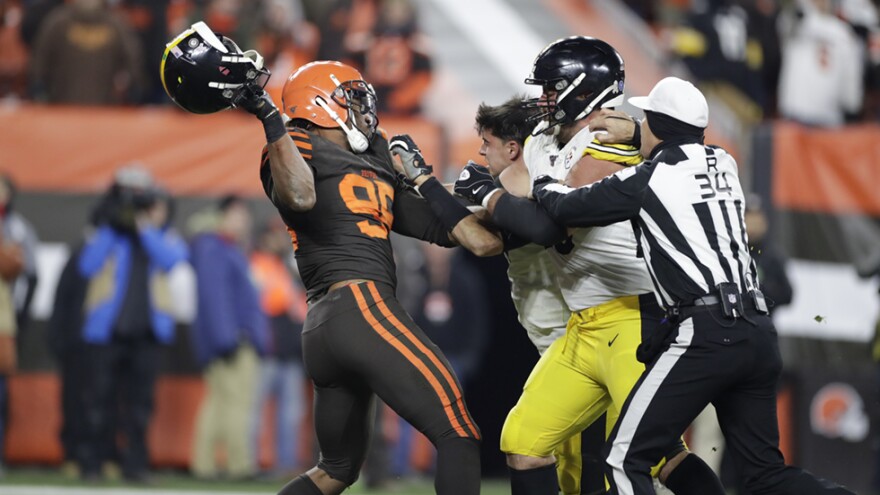 Cleveland Browns defensive end Myles Garrett, left, gets ready to hit Pittsburgh Steelers quarterback Mason Rudolph, second from left, with a helmet during the second half of an NFL football game, Thursday, Nov. 14, 2019, in Cleveland. The Browns won 21-7. [Ron Schwane / AP]