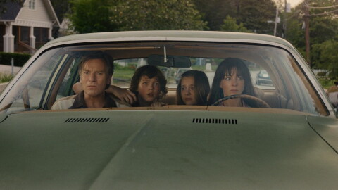 Anne Hathaway sits in a car alongside Ewan McGregor and child actors Maisy Stella and Christian Convery in the movie The End of Oak Street.
