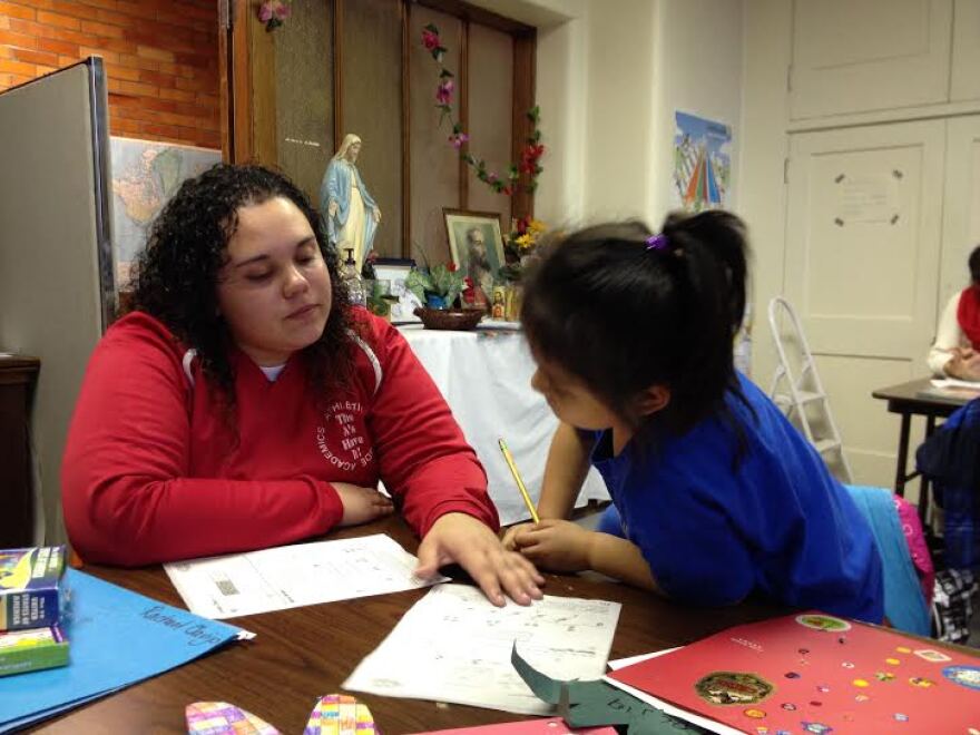 El Puente tutor, Shanel Melendez helps young student to sound out words as they read together.