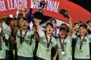 Vermont Green FC players celebrate their 2026 USL2 national championship with hats, medals and the trophy.