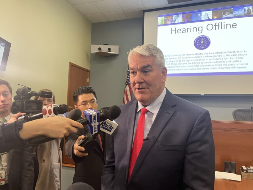 Former Indiana Utility Regulatory Commission Chair Andy Zay answers reporter questions during a break in a daylong utility affordability hearing on March 24, 2026, at the IURC’s downtown Indianapolis headquarters.