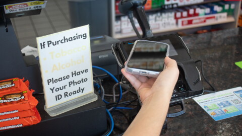 A person uses an iPhone to digitally complete a transaction at a gas station in Oklahoma City. 