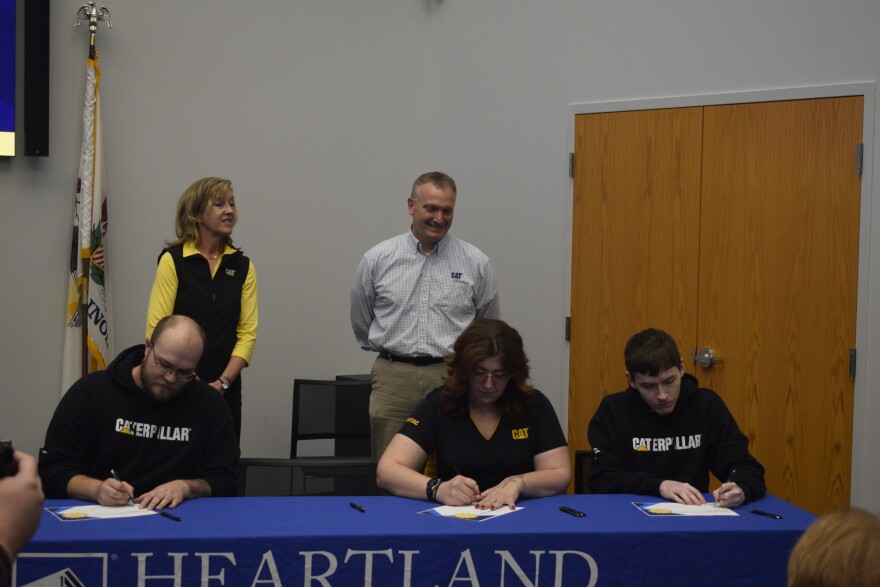 Kent Greenwell (back, center) of Caterpillar-Pontiac was one of six McLean County business partners at Heartland's signing ceremony.