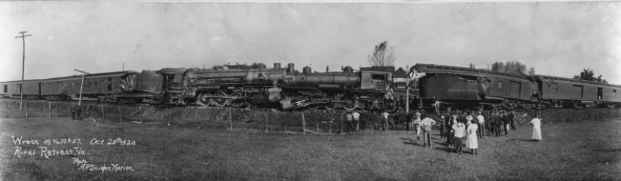Wreck of the Old 97 -- a black and white image of a train wrecked on the tracks, with people standing in the foreground looking at the sight. Text on the image indicates October 1920, Wreck of the Old 97, Rural Retreat, Va.