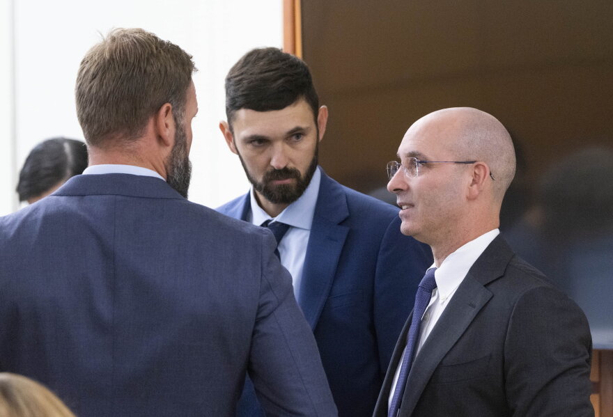 Defense attorney Jared Ausserer, right, speaks to Tacoma Police officers Matthew Collins, left, and Christopher ÒShaneÓ Burbank, center, shortly before the beginning of their trial for the killing of Manny Ellis in Pierce County Superior Court in Tacoma Wednesday, October 4, 2023.