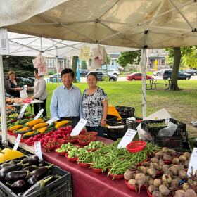 Fong Chang and Ue Xiong posing in front of the stand in the Walker Square Market.