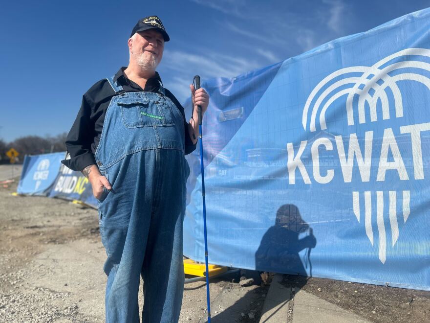 David Hutchins stands with a cane in his hand outside of Stormwater Construction 