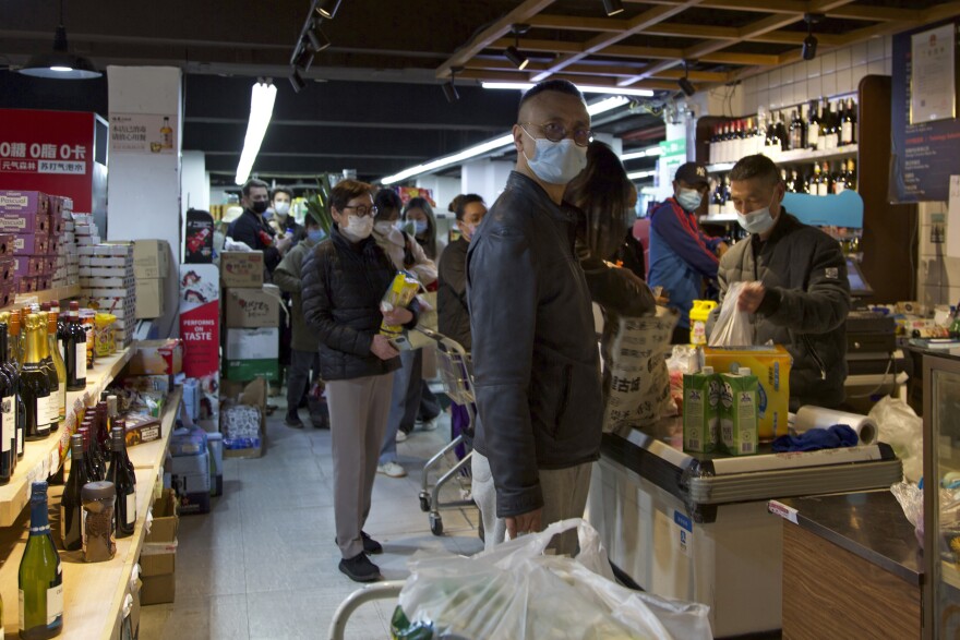 Shoppers line up to pay cashiers in a supermarket