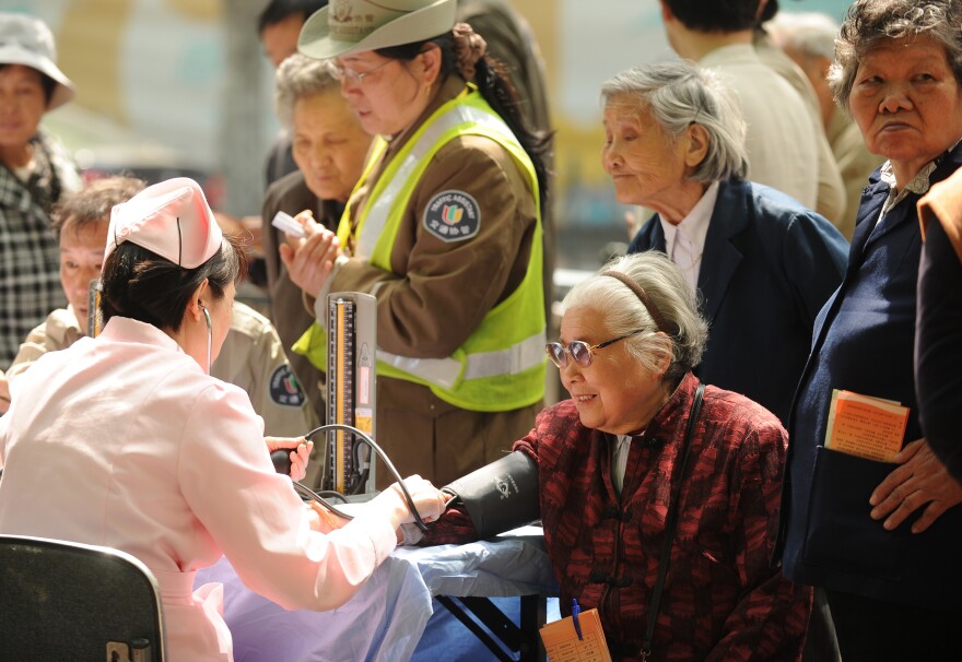 People wait to have their blood pressure checked in Shanghai in April. China's one-child policy is more than just a human rights issue; demographers warn that the low birth rate will result in a shortage of workers to drive the economy.