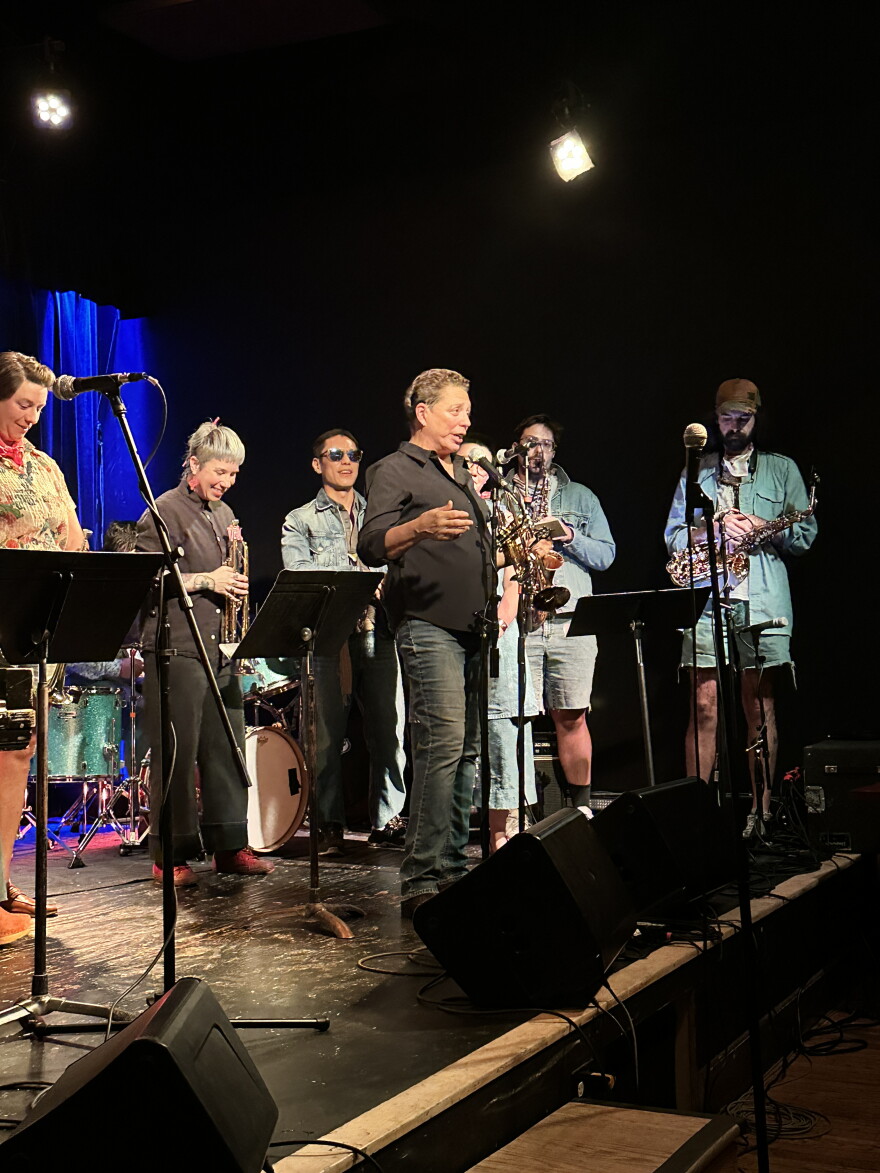 Women talks into microphone on stage