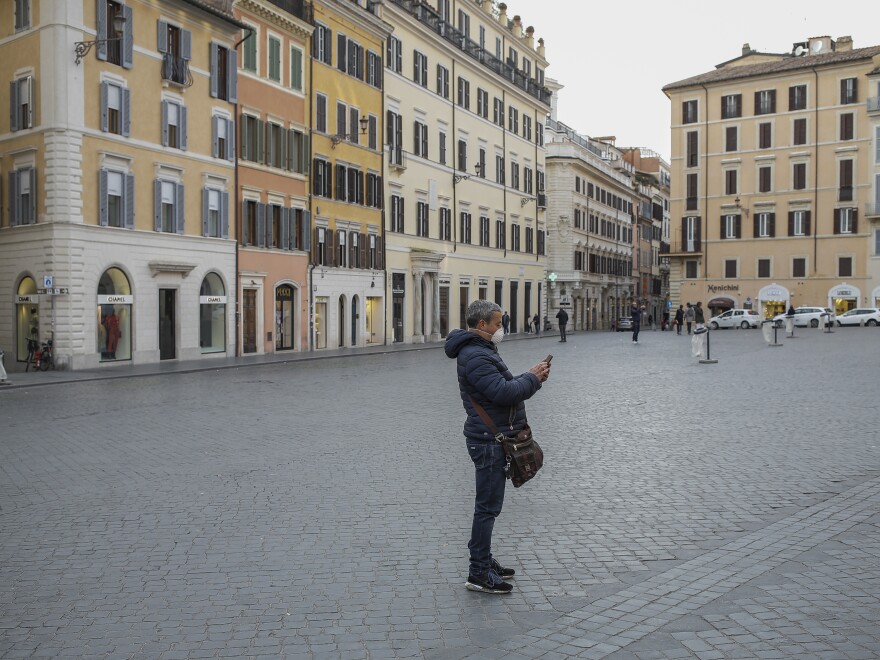 A person wearing a face mask at the Piazza Di Spagna in Rome during the coronavirus emergency, on Tuesday, after the Italian government imposed national restrictions to control the spread of the COVID-19 disease.