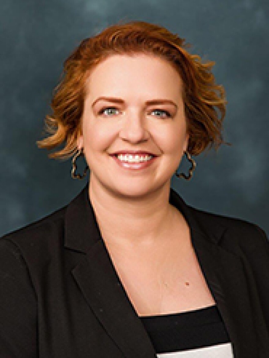 Head shot of a woman with short brown hair smiling into the camera