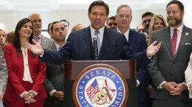 Surrounded by lawmakers, Florida Gov.Ron DeSantis speaks at the end of a legislative session, Friday, April 30, 2021, at the Capitol in Tallahassee, Fla.
