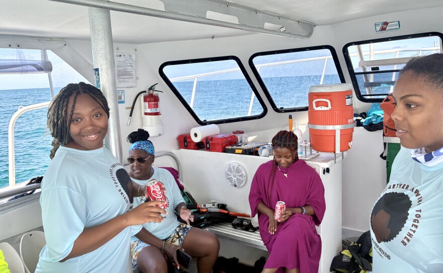  Angeni Nettles (far left), Shellie Baxter (left),  Marlynn Rollins (right), and  Alana Lara (far right) dry off after a dive