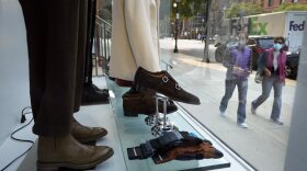 People look at some clothes through a storefront window in Boston.