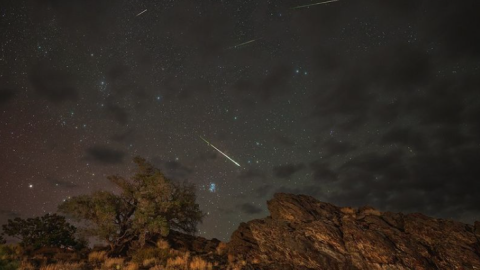 Meteors from the Perseids Meteor Shower streak across a partly cloudy sky above Inyo National Forest in Bishop, California, in 2024.