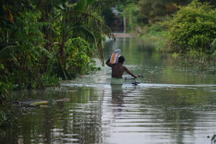 An Indian villager wades through floodwaters in West Bengal on Aug. 23.